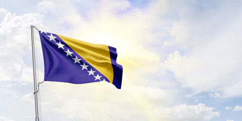 Bosnia and Herzegovina flag waving on sky background. 3D Rendering