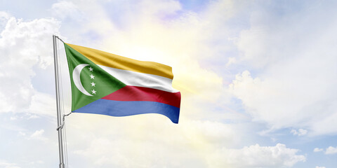 Comoros flag waving on sky background. 3D Rendering