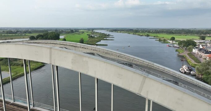 Drone flying over the Culemborg railway bridge revealing a passenger ferry on The Lek River