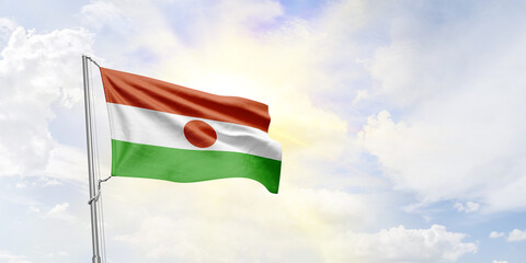 Niger flag waving on sky background. 3D Rendering