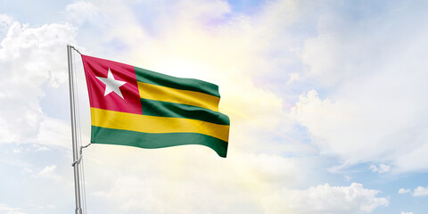 Togo flag waving on sky background. 3D Rendering