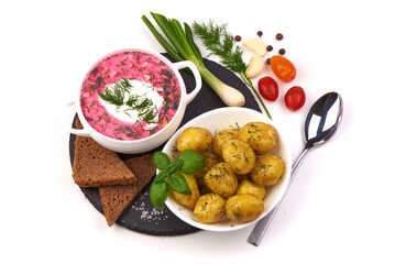 Traditional cold beetroot soup served with boiled potatoes, isolated on white background.