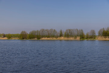 Fototapeta premium The blue water in the lake reflects the blue sky in spring