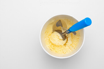 Tub of vanilla ice cream and scoop