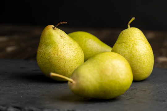 a green ripe pear on the table - Powered by Adobe