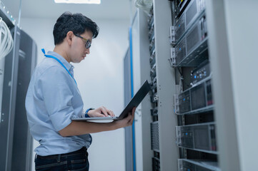 Computer engineer is setting up network in server room,Systems Maintenance Technician,Male engineer working in server room at modern data center