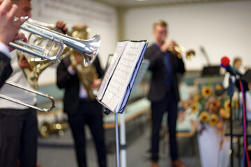 A musician in an orchestra plays a musical composition on a trumpet in an orchestra. © andov