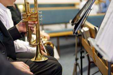 A male musician plays the trumpet in a folk brass band.