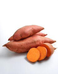 sweet potato whole and sliced scattered around background concept isolated white