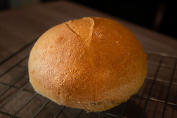 Classic white bread loaf on a grill. This homemade rustic roll ball bun is made of organic white wheat flour for a sourdough recipe.
