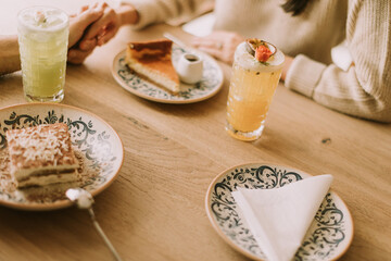 Sharing delightful desserts and refreshing drinks at a cozy cafe table during a sunny afternoon with friends