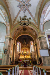 VILEIKA, BELARUS - SEPTEMBER 12, 2024: altar in interior of old catholic church with columns and frescoes.