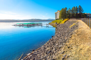 Obraz premium Luxury waterfront condominiums and a small marina with boat slips and docks along the shores of Lake Coeur d'Alene near the downtown district of Coeur d'Alene, Idaho USA.