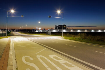 night street with pedestrian crossing near the bus stop, industrial zone