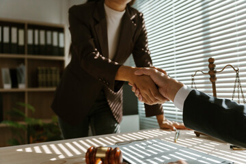 Two lawyers shaking hands in agreement in their office after reaching an agreement in a lawsuit