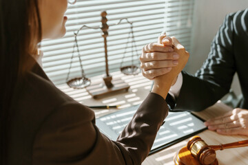 Two lawyers shaking hands after reaching an agreement in a lawsuit, with a scale of justice and a...