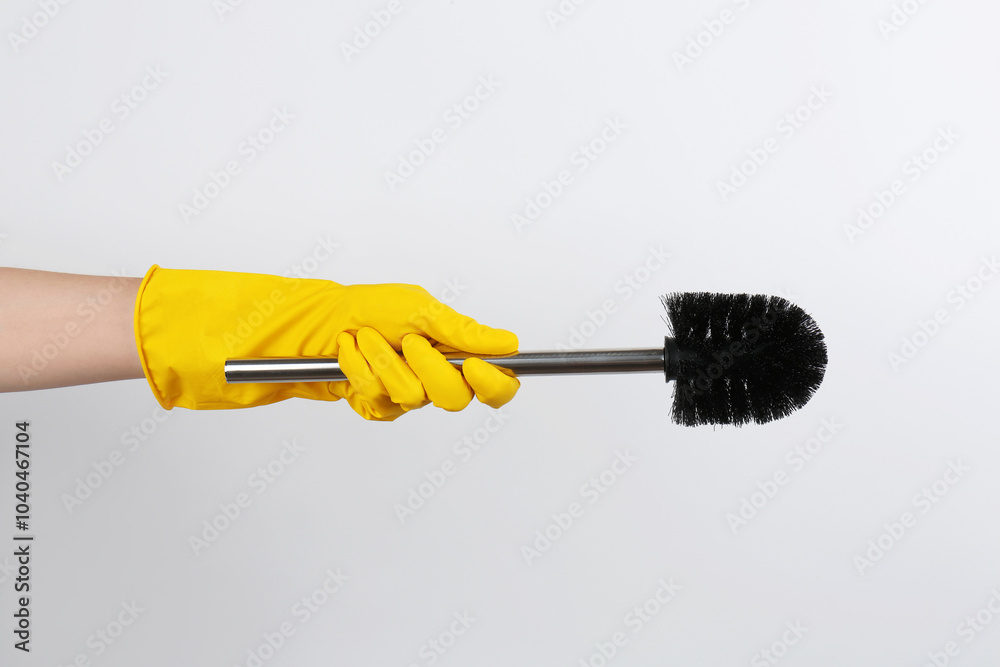 Wall mural Woman holding black toilet brush on light background, closeup. Cleaning tool