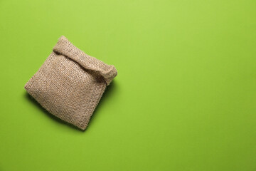 One burlap sack on light green background, top view. Space for text