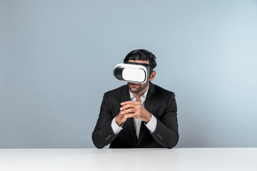 Professional businessman wearing visual reality glasses and suit while sitting. Smart caucasian project manager looking at data analysis by using VR headset. Innovation technology concept. Deviation.