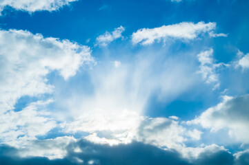 Blue sky background, picturesque vast blue sky landscape, panoramic sky scene with dramatic white clouds lit by sunlight