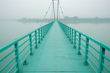 Fototapeta premium A tranquil pale green bridge spanning turquoise waters beneath a soft pale blue sky backdrop