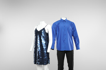 Female and male mannequins with stylish outfits on light background