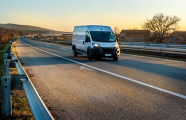 White cargo van at the open highway at sunset