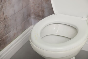 Urine drops on toilet seat in restroom