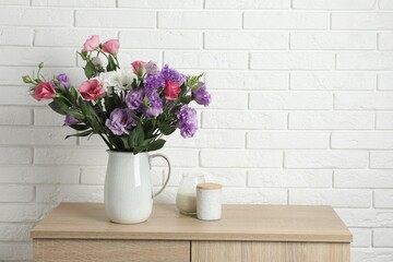 Vase with beautiful eustoma flowers on wooden chest of drawers, space for text