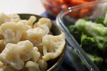 Frozen cauliflower and broccoli on table, closeup