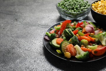 Different frozen vegetables on grey table, closeup. Space for text