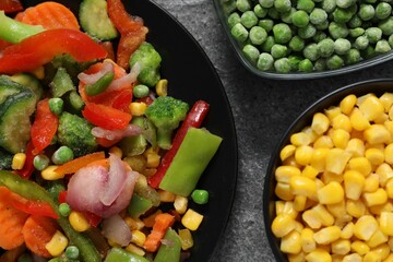 Different frozen vegetables on grey table, top view