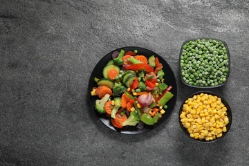Different frozen vegetables on grey table, top view. Space for text