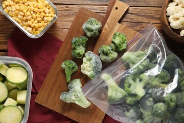 Different frozen vegetables on wooden table, top view