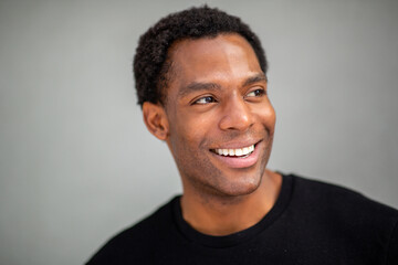 Man smiling and looking to the side on gray background