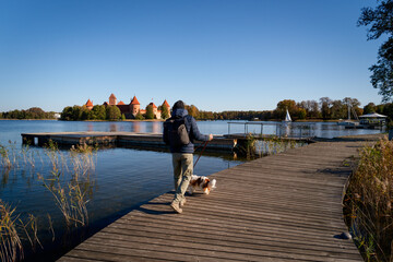 Man with dog on Old Lithuania castle trakai landscape 