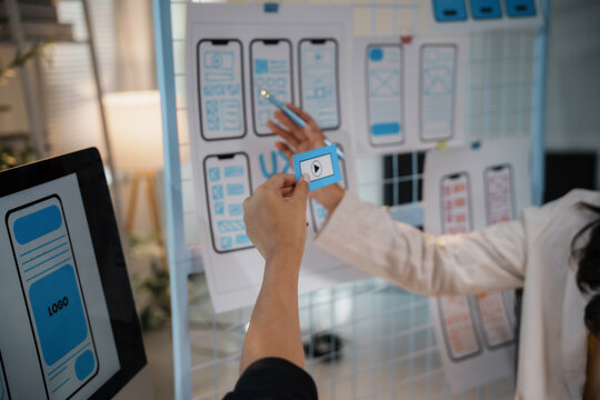 Uiux designers reviewing mobile application interface design during a brainstorming session