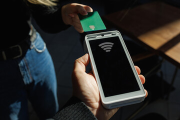 Close Up of a Masculine Hand Holding a Credit Card with an NFC Payment Technology Used for Paying
