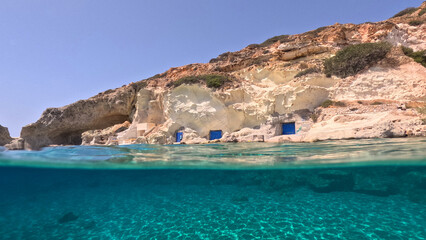 Underwater split photo of small cove of Rema famous for colourful boat houses called Sirmata, Kimolos island, Cyclades, Greece