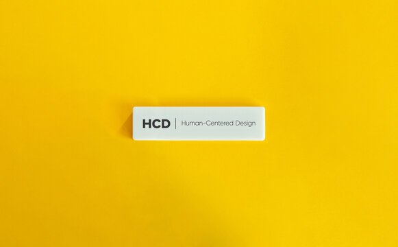 Human-Centered Design (HCD) Background. Approach to Interactive Systems Development. Text on Block Letter Tile on Yellow Background. Minimal Aesthetic.
