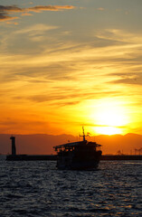Fototapeta premium Sea sunset with silhouette of touristic boat in front of sun