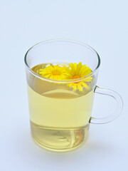 cup with drink from calendula flowers on white background