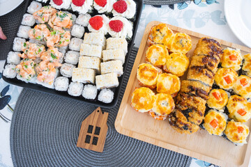 Delivery of sushi and rolls set top view on the table at home on a napkin, home cooking