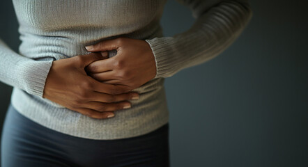 Close up of a woman holding her abdomen in pain with room for text 