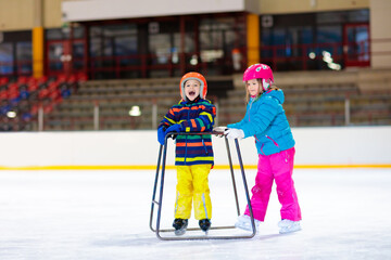 Child skating on indoor ice rink. Kids skate.