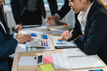 Business team working together, analyzing financial documents with charts and graphs at office desk