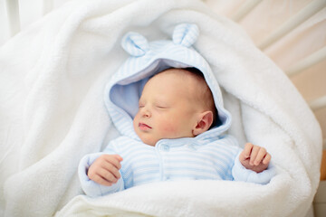 Newborn baby boy in hospital cot