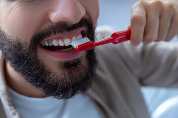 daily dental care and oral hygiene. Man with beard in dentist’s office holding toothbrush