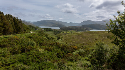 The beautiful nature in Scotland with the Lochs, mountains, rolling hills and cloudy skies and the green forests