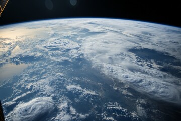 Fototapeta premium A stunning image features Earth enveloped by swirling clouds, offering a striking display of atmospheric dynamics, natural shapes, and the planet's grand scale.